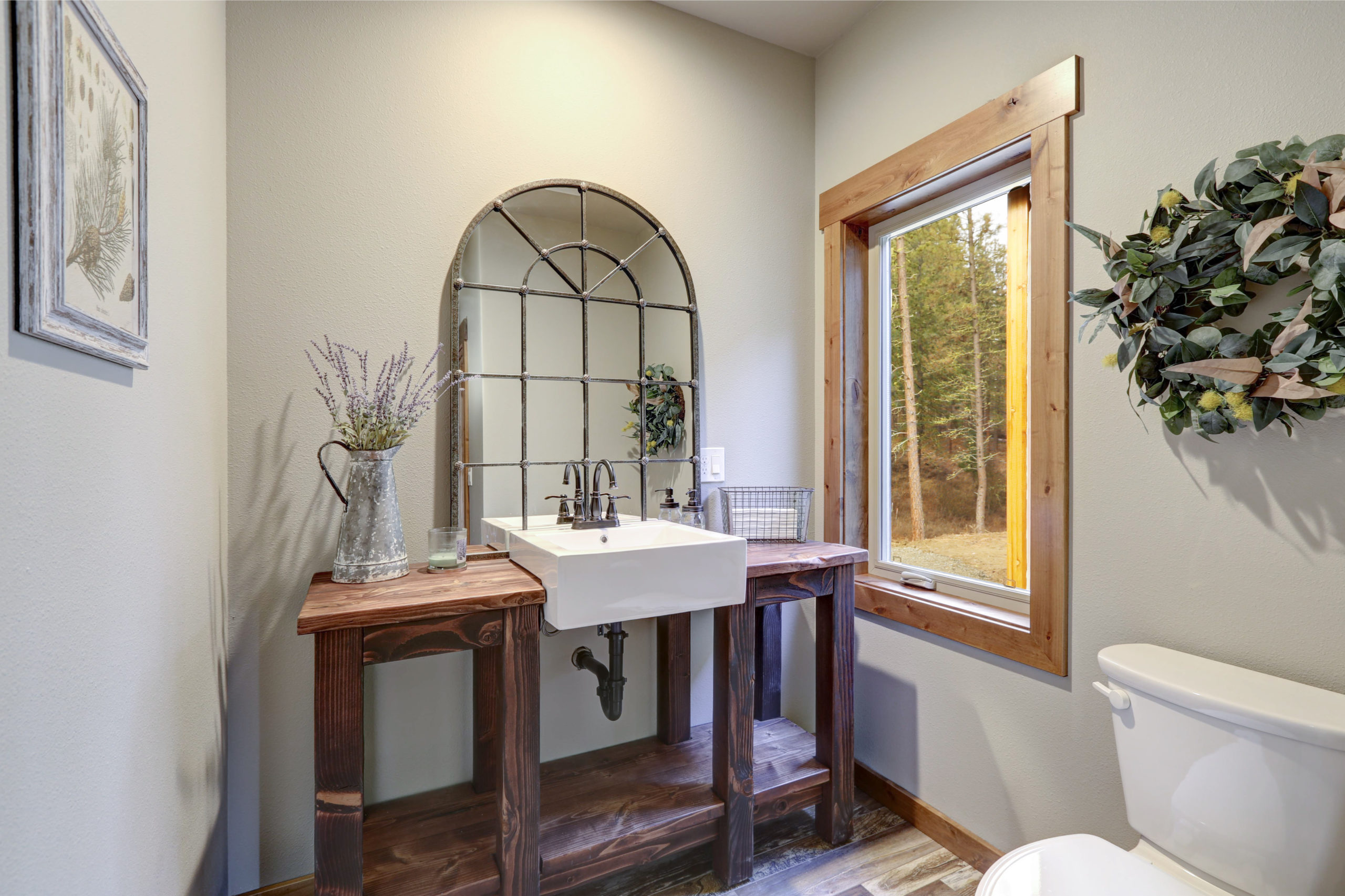 Fantastic bathroom boasts a country style washstand adorned with iron cage mirror